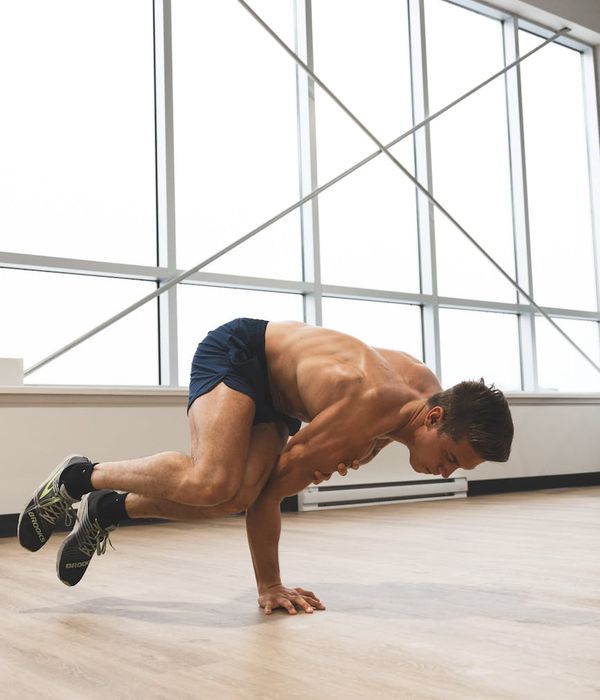 Man performing a dynamic strength exercise in a modern studio.